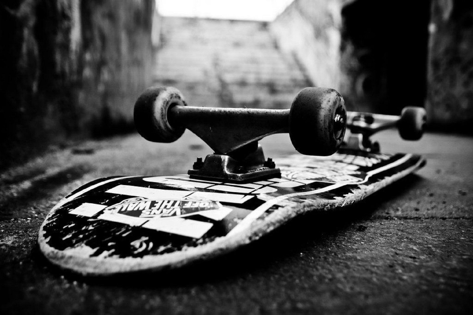 Arafed skateboard laying on the ground in a dark alley (man, skateboard, sports, weights)