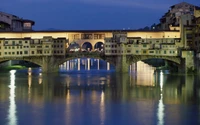 Reflejo nocturno del Ponte Vecchio sobre el río Arno