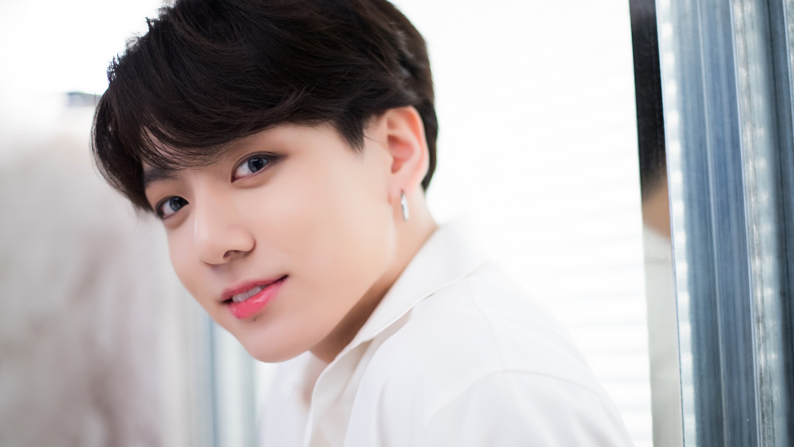 Un hombre árabe asiático con una camisa blanca y aretes mirando a la cámara (jungkook, jeon jeong guk, bts, bangtan boys, kpop)