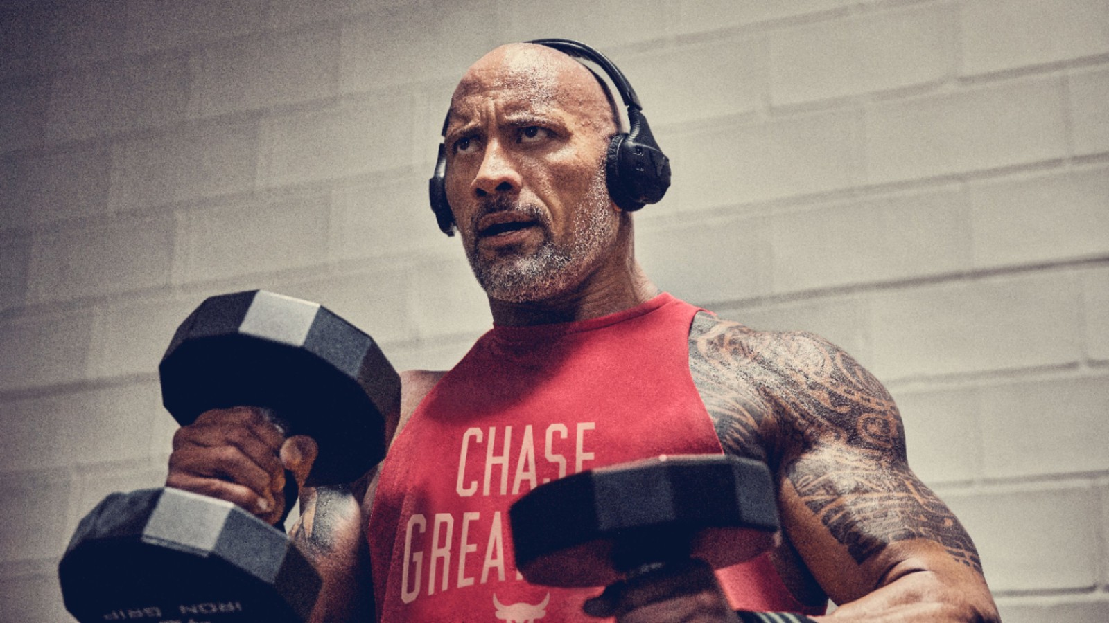 Hombre árabe con auriculares y camiseta roja sosteniendo una mancuerna (celebridad)