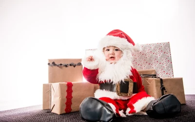 Adorable bebé Santa rodeado de regalos de Navidad