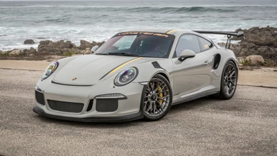 Porsche 911 GT3 con modificaciones personalizadas de Vorsteiner, estacionado en una carretera costera escénica.