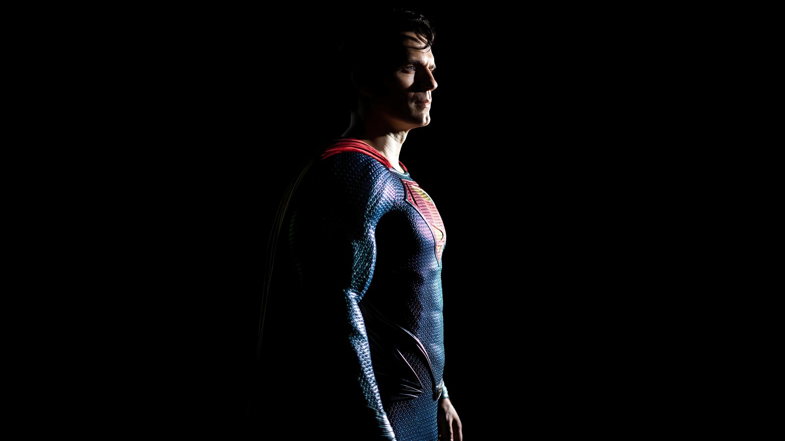 Un gros plan d'un homme en costume de superman debout dans l'obscurité (homme dacier, superman, henry cavill, film)