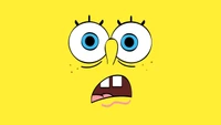 Surprised and expressive cartoon face with big eyes and a comical mouth, set against a bright yellow background.