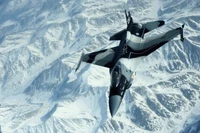 Fighter Jet Maneuvering Over Majestic Snow-Capped Mountains