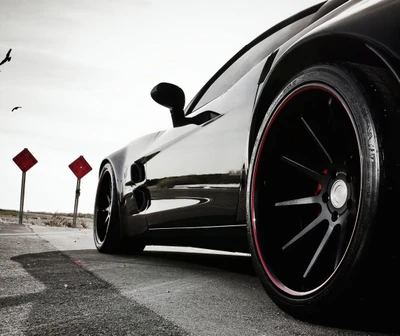 Sleek Black Sports Car Racing Down an Open Road