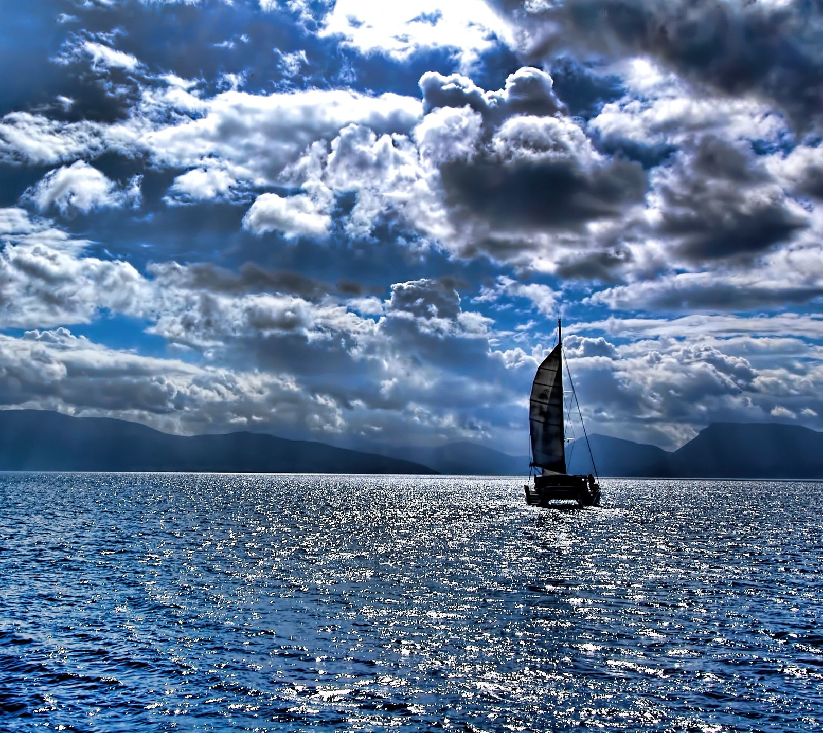 Há um veleiro navegando no oceano sob um céu nublado (hd, oceano, navio)