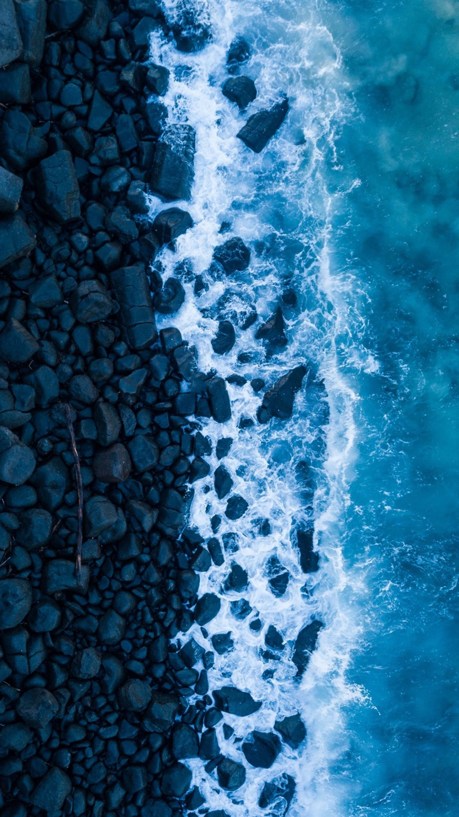 Vista aérea de uma pessoa em uma prancha de surf pegando uma onda (mar, azul, relaxamento)