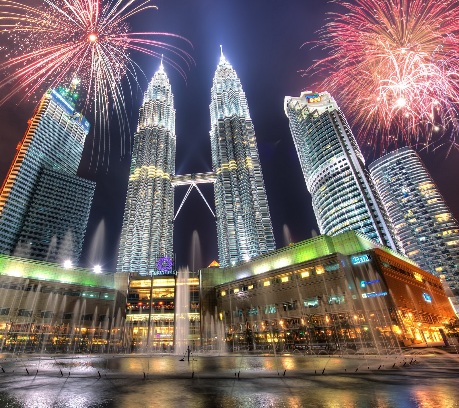 Des feux d'artifice illuminent le ciel au-dessus d'une ville avec de grands bâtiments (incroyable, bâtiment, ville, hôtel, éclairage)