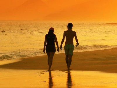 Silhouetted Couple Walking Hand in Hand at Sunset