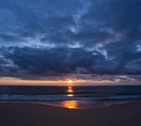 Serene Sunset Over a Tranquil Beach with Blue Hues