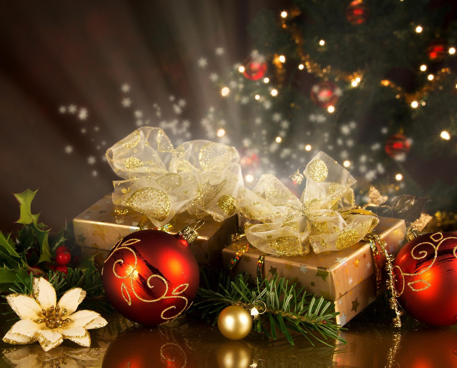 Christmas decorations and gifts on a table with a christmas tree in the background (new, year)