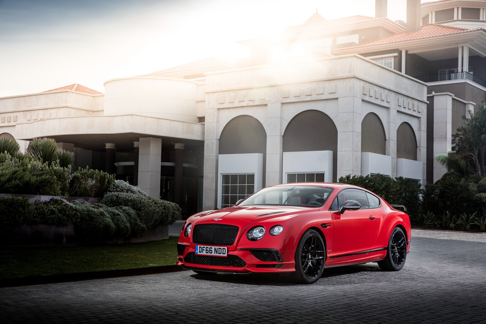 A red bentley car parked in front of a large building (bentley, car, bentley motors limited, bentley continental gt, bentley continental flying spur)