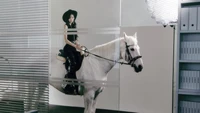 Kazuha of LE SSERAFIM in a striking "Dusty Amber" concept, elegantly riding a white horse in a modern office setting.