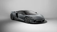 Sleek McLaren GT in a modern gray finish, showcasing its aerodynamic design and luxury features.