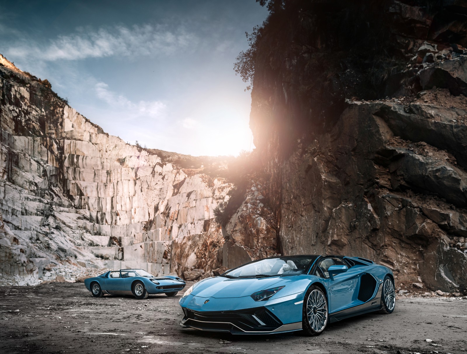 Dos corderos azules aparcados frente a un acantilado rocoso (lamborghini aventador lp 780 4 ultimae miura roadster, lamborghini miura roadster 1968, 2023, 5k, coches)