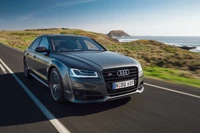 Audi A8 on a scenic coastal road, combining luxury and performance.