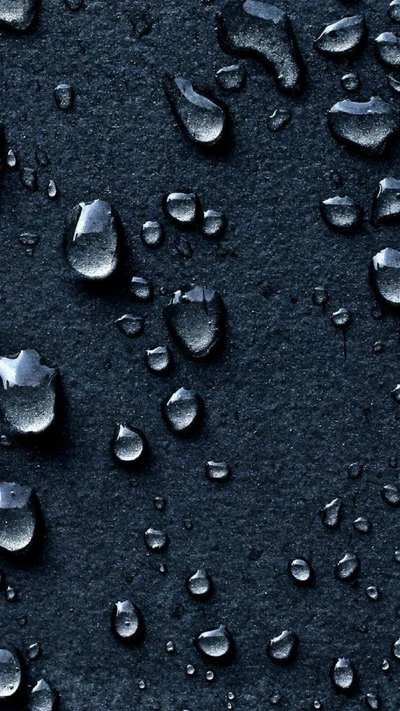 Close-up de gotas de água em uma superfície escura