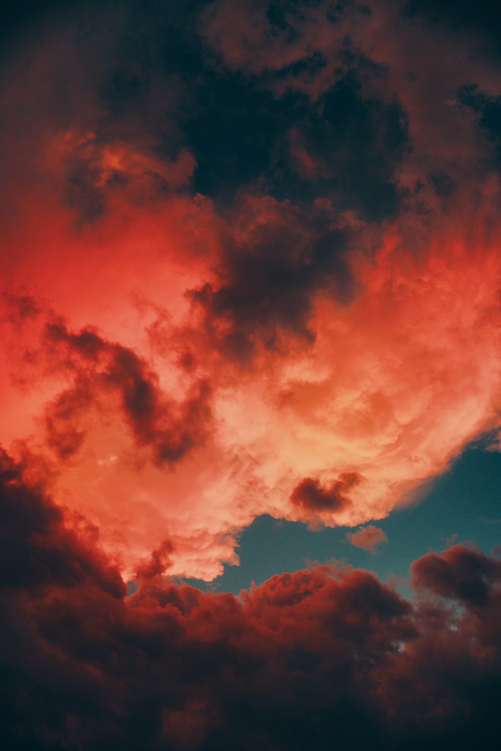 Il y a un avion qui vole à travers un ciel nuageux avec un ciel rouge (nuage, crépuscule, rouge, journée, orange)