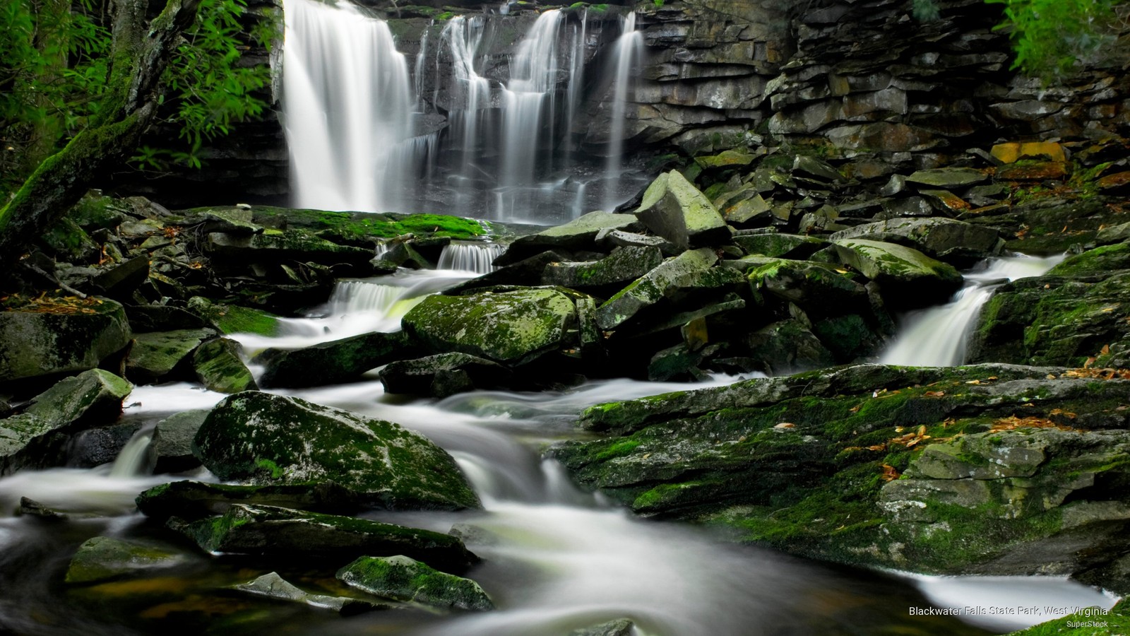 A close up of a waterfall with rocks and water in the foreground (waterfall, state park, park, national park, nature reserve)