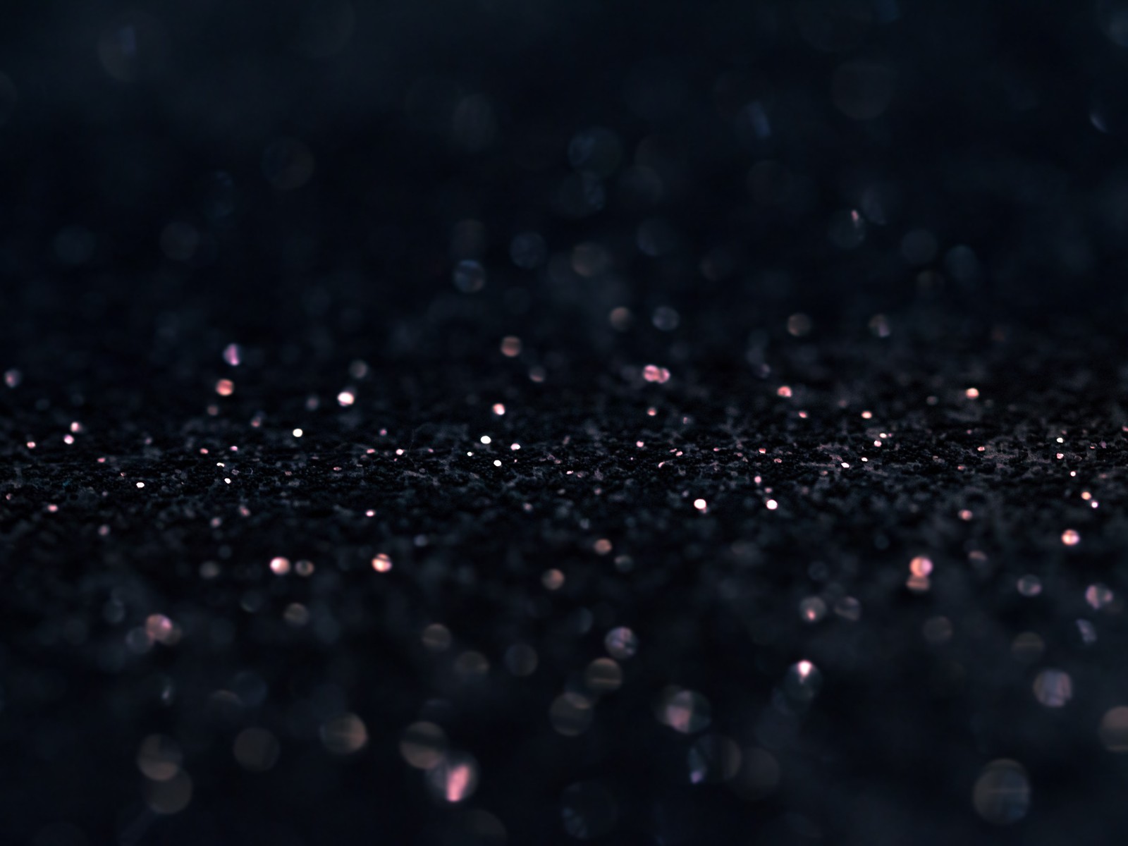 Un primer plano de un fondo negro con pequeños puntos blancos (bokeh, negro, noche, agua, atmósfera)