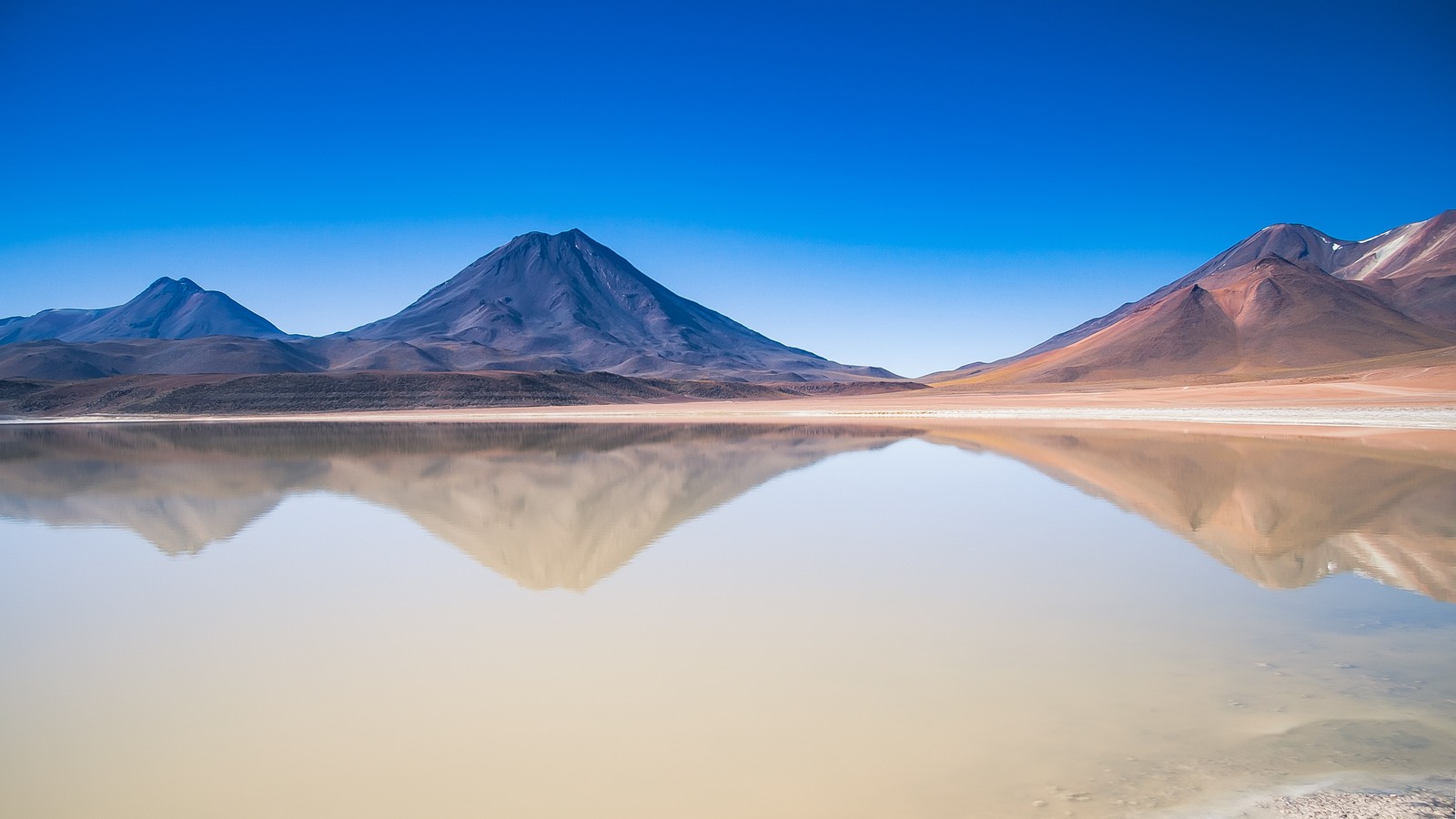 Arafed mountain range reflected in a lake with a clear sky (lascar volcano, san pedro de atacama, chile, body of water, lake)