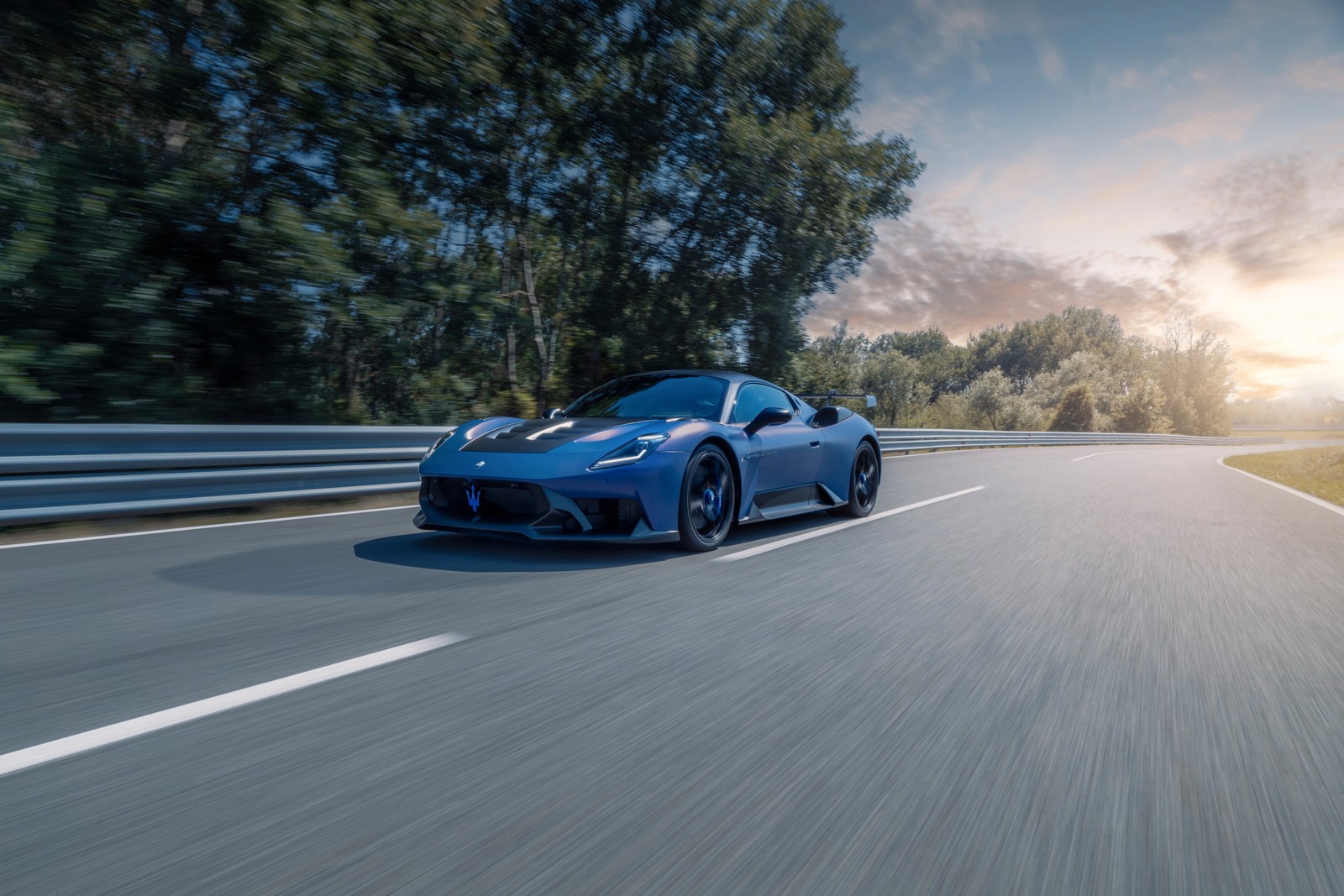 Une voiture de sport bleue roulant sur une route avec des arbres en arrière-plan (maserati gt2, 2024, 5k, voitures, fond décran 4k)