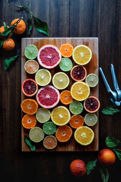 Exhibición colorida de cítricos en una tabla de madera