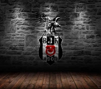 Besiktas JK Logo with Eagle Emblem on Stone Wall Background