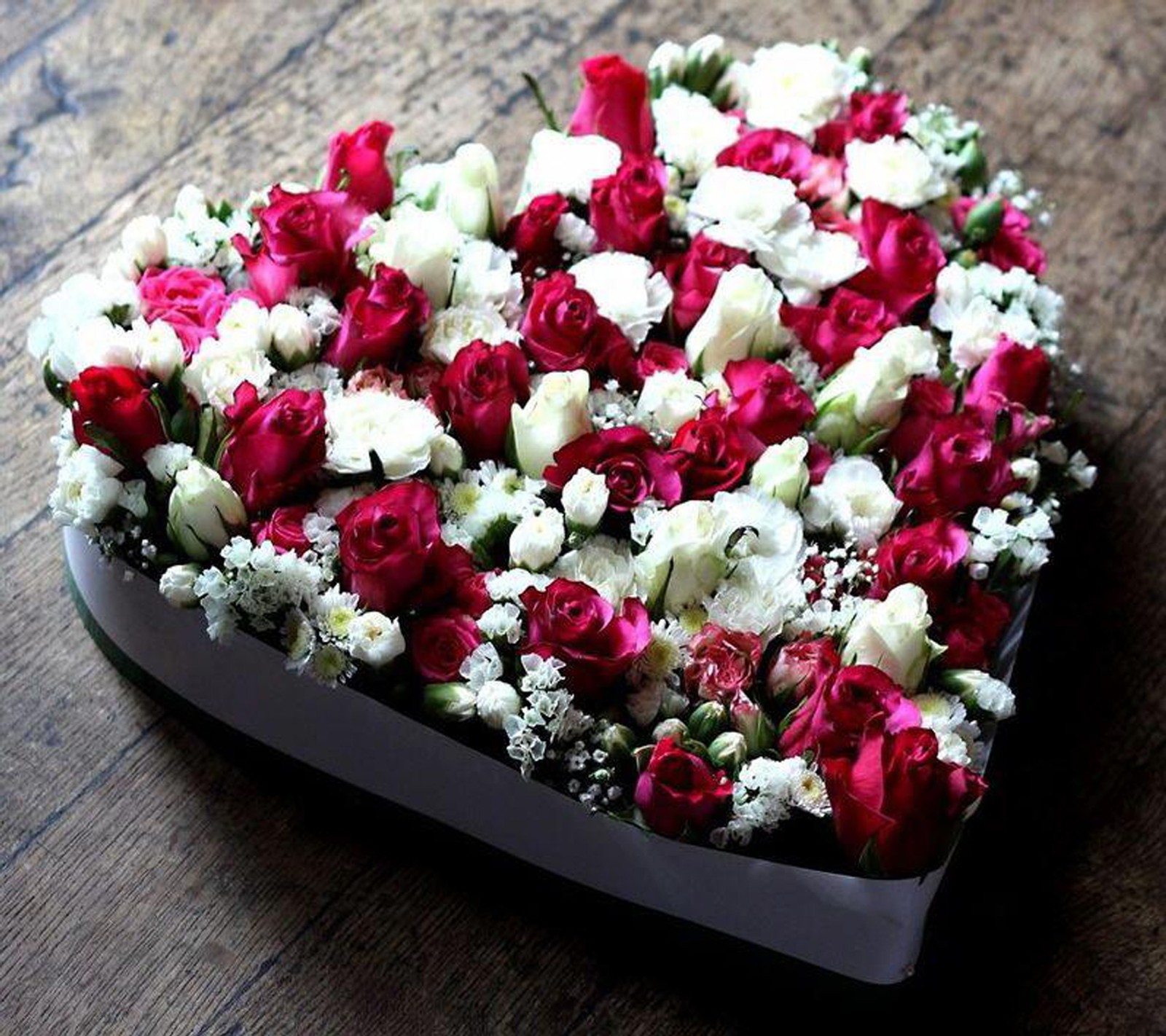 Une boîte en forme de cœur avec des fleurs sur une table (amour, papier peint)