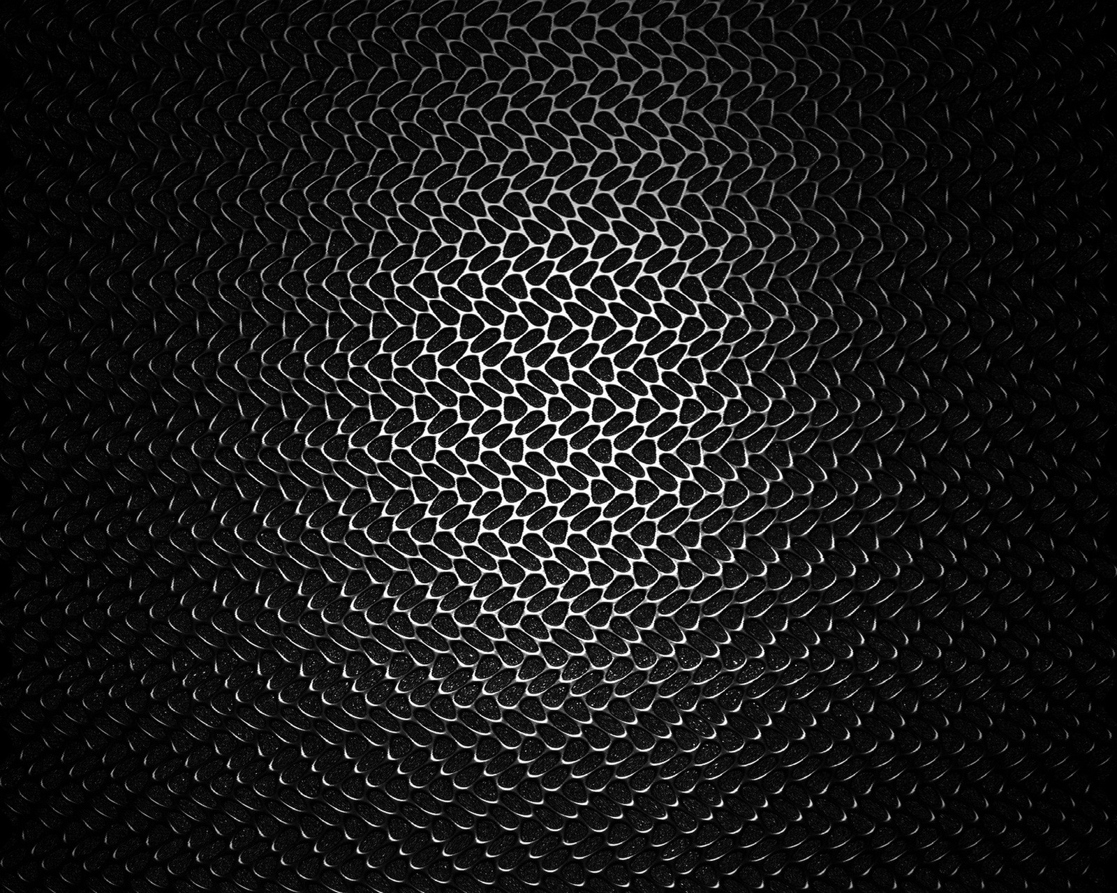 A black and white photo of a metal surface with a pattern (black, metallic texture pattern)