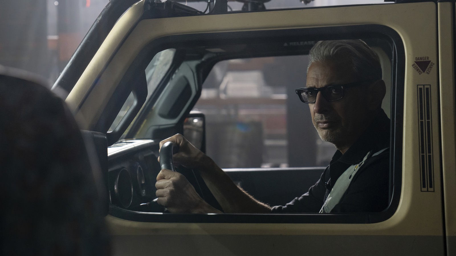 Ein arabischer mann fährt einen lkw mit einem lenkrad in einer stadt (jeff goldblum, dr ian malcolm, jurassic world dominion, film, 2022)