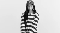 Minji de NewJeans dans une tenue rayée et une casquette