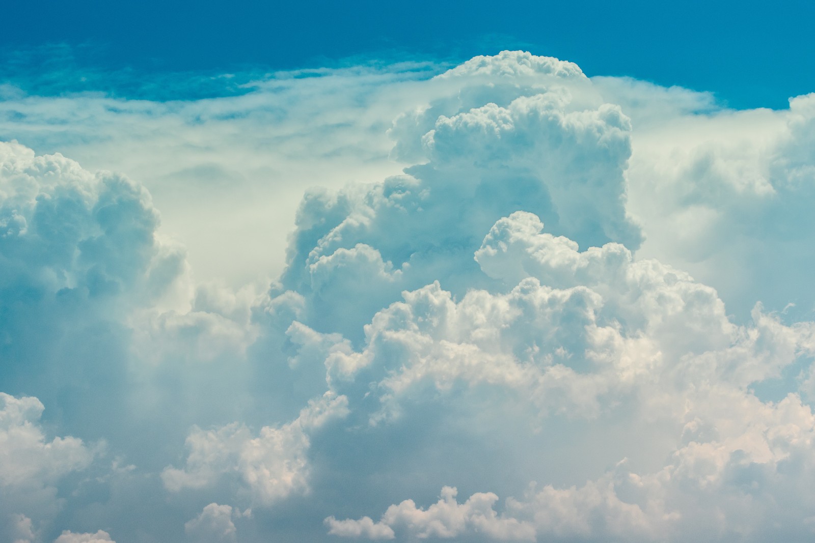 Un avion volant à travers les nuages dans le ciel (nuage, journée, bleu, cumulus, atmosphère)