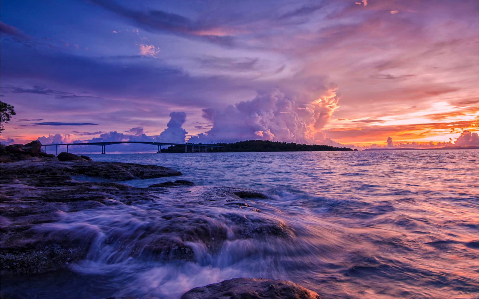 Vue d'un pont sur un plan d'eau au coucher du soleil (coucher de soleil, nuage, mer, horizon, océan)