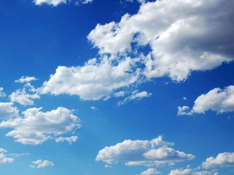 Un grand champ avec quelques personnes dessus (nuage, bleu, journée, cumulus, atmosphère)