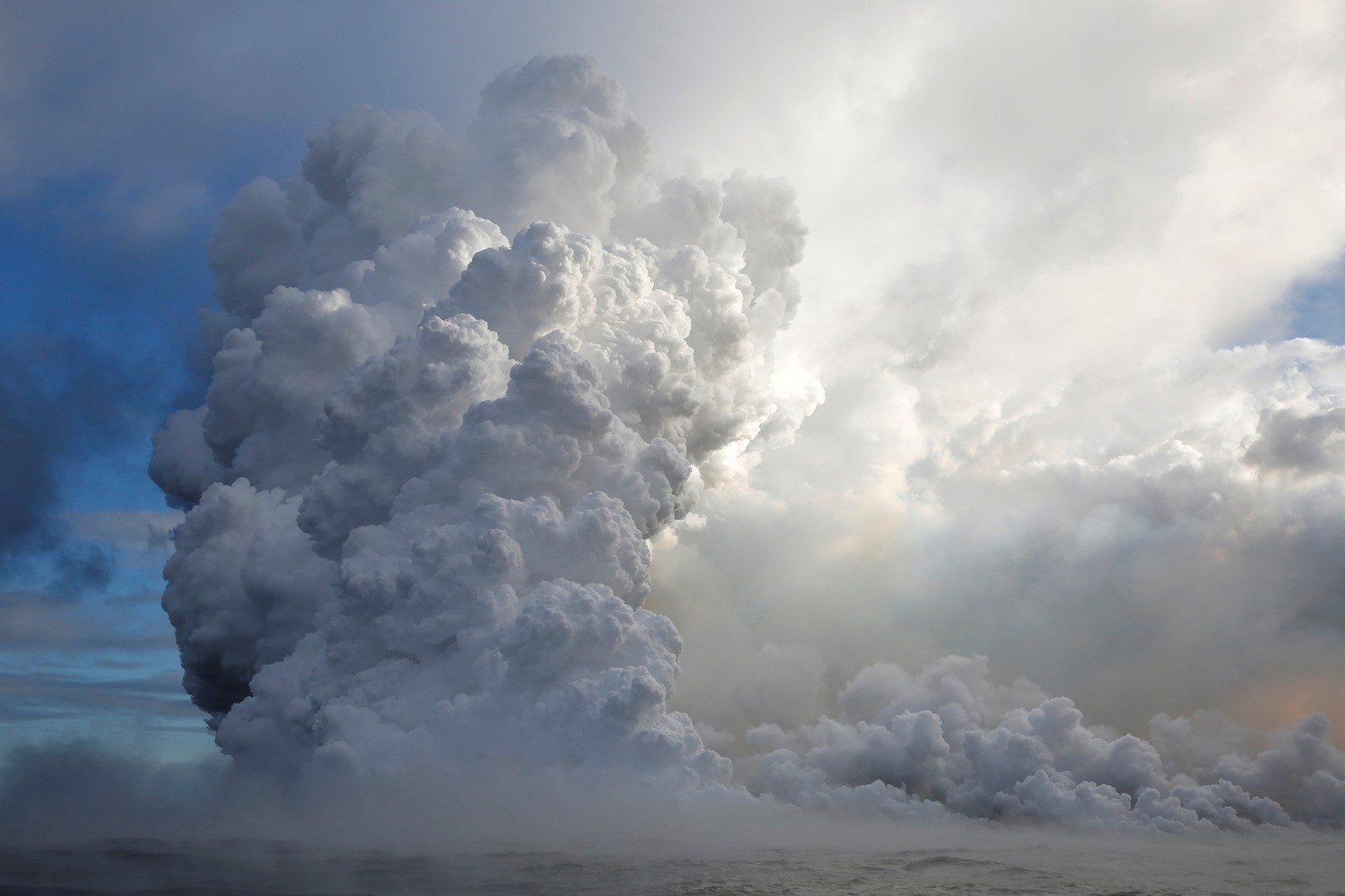 De la fumée douce s'échappant d'un nuage d'eau (cumulus, volcan, lave, nuage, journée)