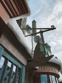 Monumento cubierto de nieve en el Callejón Diagon con señalización de hierro