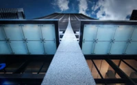 Upward Perspective of a Modern Skyscraper Against a Cloudy Sky