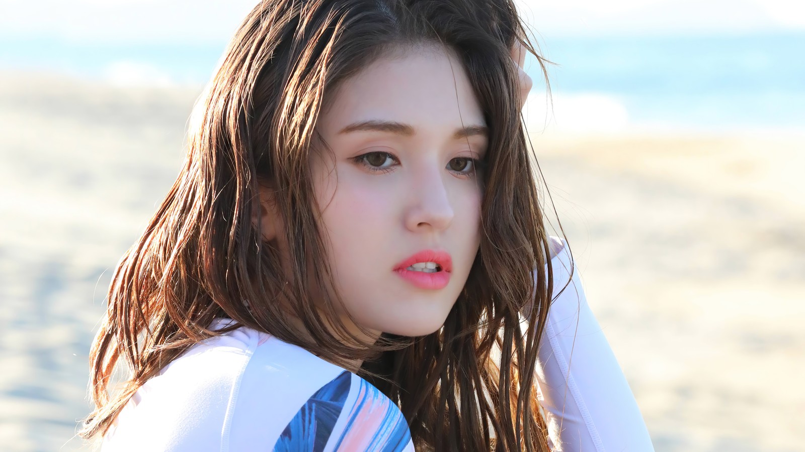 Una chica con cabello largo y una camisa blanca en la playa (somi, 소미, ennik somi douma, jeon somi, jeon so mi)