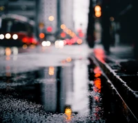 Reflections of Urban Life: A Rainy Street Scene with Vibrant Lights