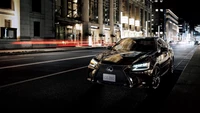 Lexus GS350 estacionado sob as luzes da cidade, exibindo um design elegante e recursos automotivos modernos.