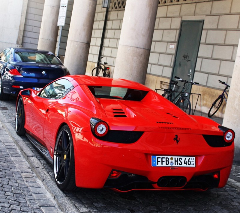 Спортивный автомобиль ferrari припаркован у дороги рядом с велосипедом (машина)