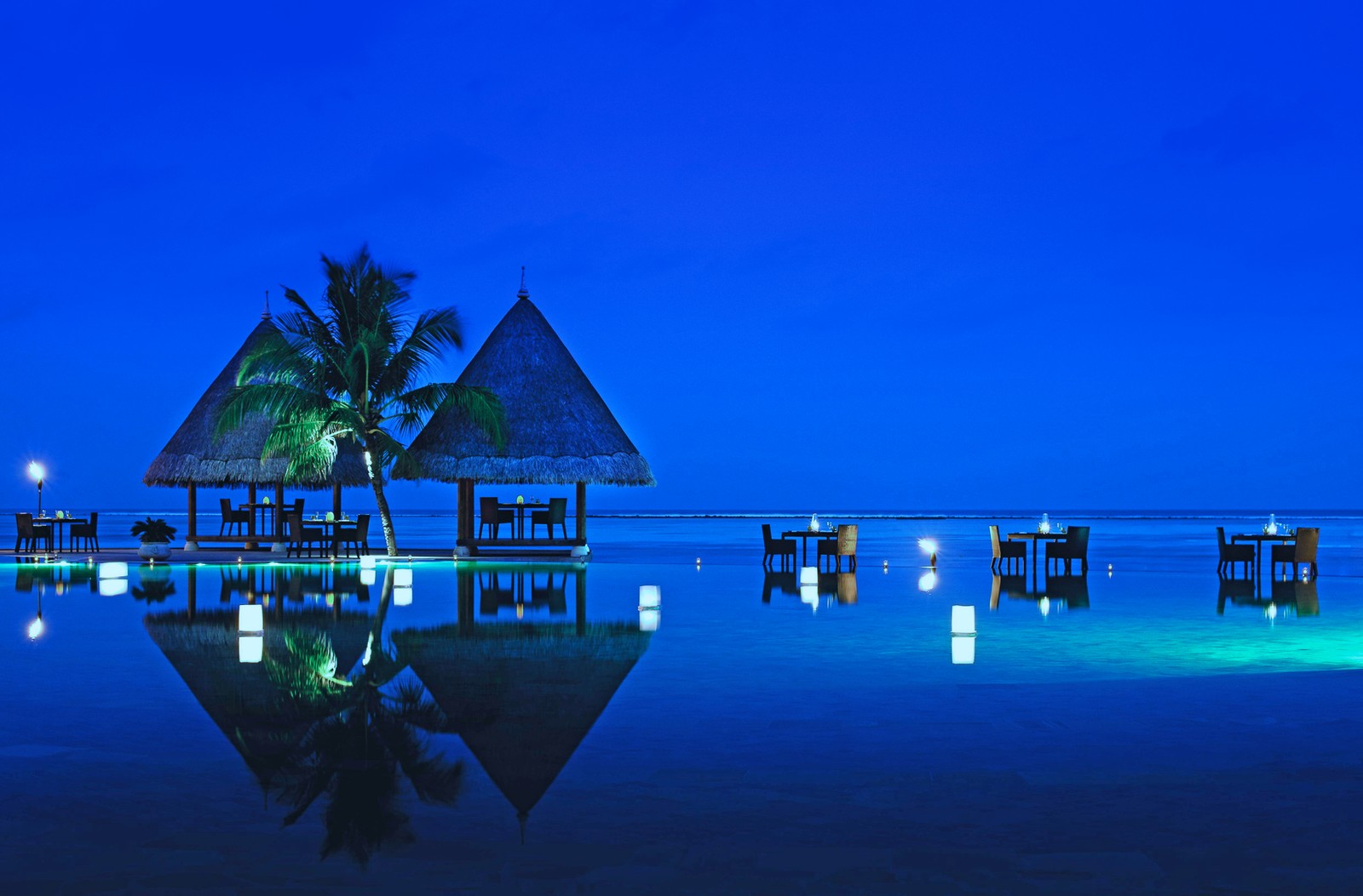 Aussicht auf einen strand mit einem pool und einem restaurant bei nacht (blau, reflexion, wasser, architektur, atmosphäre)