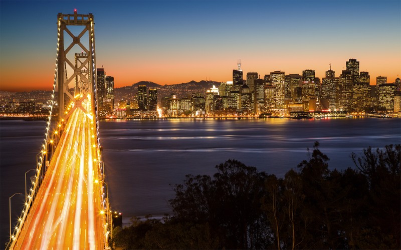 Вид на город с силуэтом зданий, мостом и водоемом (мост золотые ворота, golden gate bridge, мост, городской пейзаж, достопримечательность)