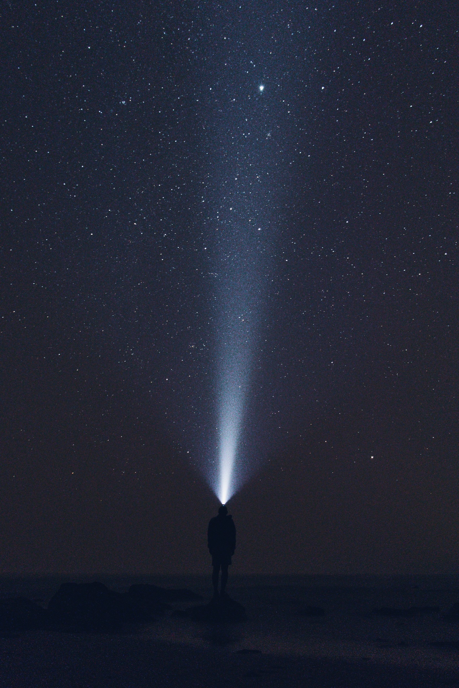 Uma imagem distorcida de uma pessoa em pé no meio de um campo com luz saindo de sua cabeça (atmosfera, noite, escuridão, espaço, estrela)