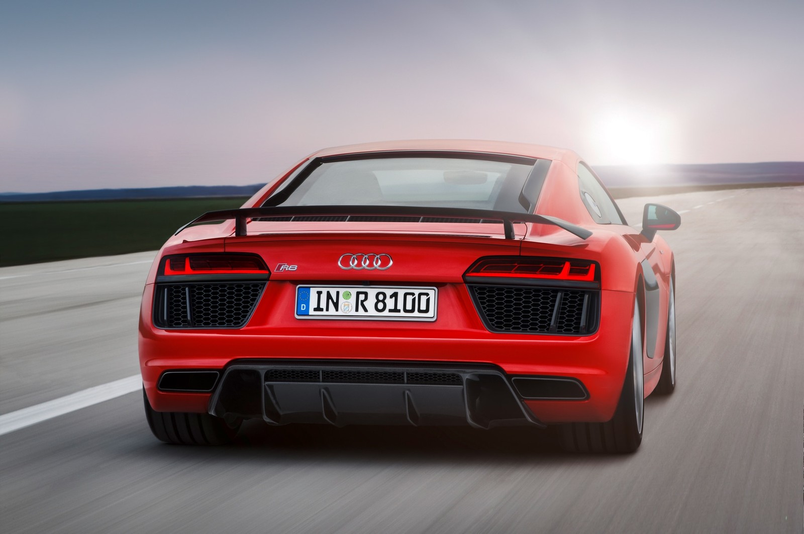 Um carro esportivo vermelho dirigindo por uma estrada com o sol brilhando (carro, audi r8, audi, carro esportivo, supercarro)