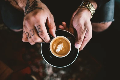 Artfully Crafted Espresso with Leaf Design in Tattooed Hands