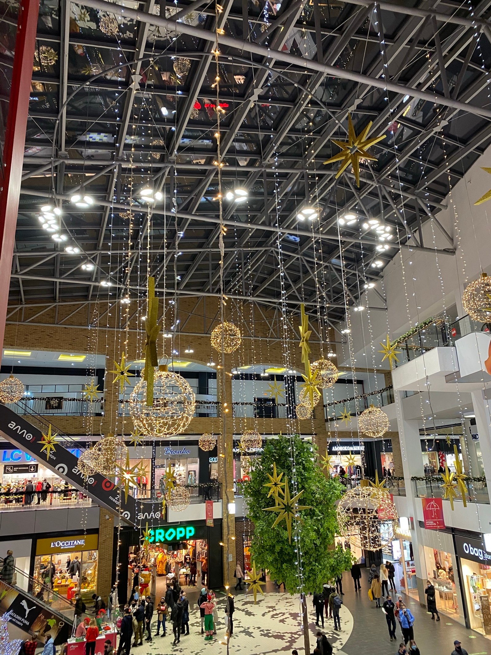 Multitudes de personas árabes caminando por un centro comercial con decoraciones navideñas (centro comercial, multitud, iluminación, arquitectura, noche)