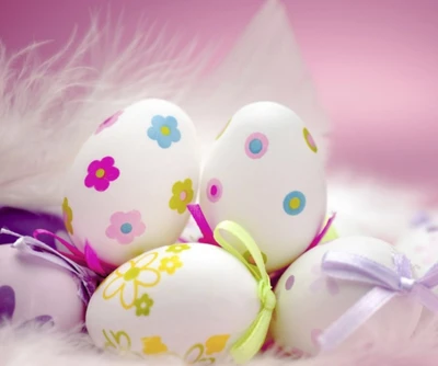 Colorful decorated Easter eggs with floral patterns and ribbons on a soft, feathery background.